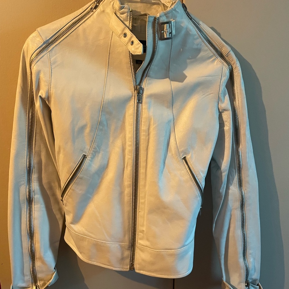 White leather jacket with silver zippers.  Very cute on!!